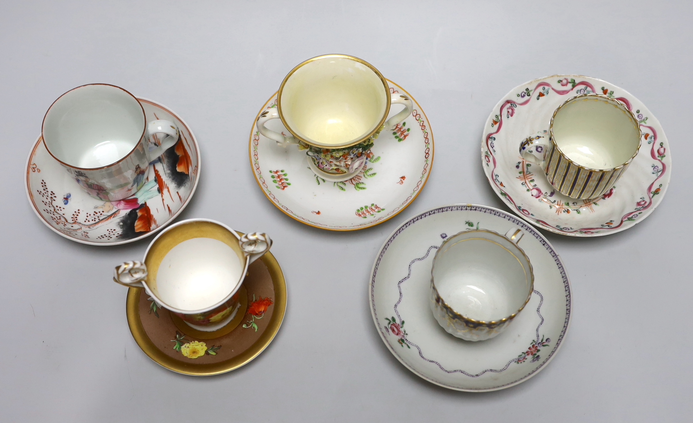 A group of early 19th century English porcelain cups and various saucers to include a Spode two handled chocolate cup and saucer (10)